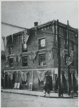 The building, located on the corner of Temple Street and 3rd Avenue, is decorated in American flags. 