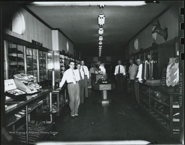Gentleman third from the left is identified as "Punchy" Neely. The rest are unidentified. Interior of the store located on Temple Street. 