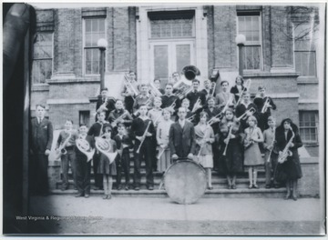 Photo taken of an old class photo at Hinton High School. The group appears to be the school's marching band and conductor. Subjects unidentified. 