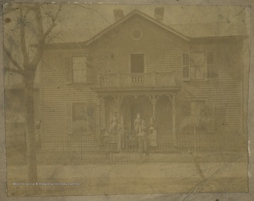 Family pictured in front of the house. Subjects unidentified. 