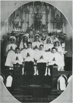 Two priests and a group of children are pictured on the altar. The priest on the left is believed to be Fr. John Werninger. Other subjects unidentified. 