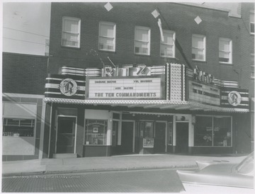 Street view of the building located on Ballengee Street. The theatre is advertising The Ten Commandments. 