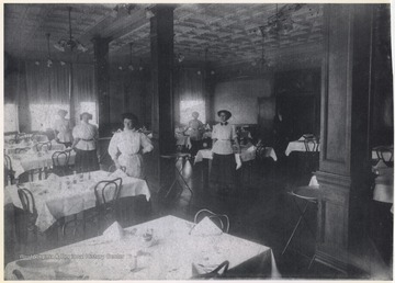 Female employees pose by the set tables around the room. Subjects unidentified. 