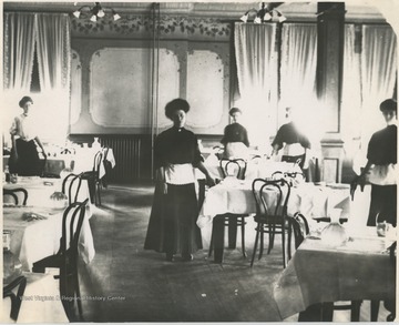 Female employees pose by the set tables.Subjects unidentified. 