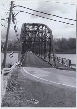 Two cars drive across the bridge that runs over Cheat Lake and along Country Route 857. The bridge was built in 1922 by the Independent Bridge Company of Pittsburgh. 