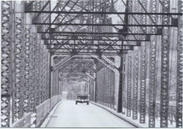 A lone car drives over the bridge that runs across Cheat Lake and along County Route 857. The bridge was built in 1922 by the Independent Bridge Company of Pittsburgh. 