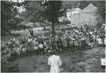 A crowd assembles on the lawn to hear a speaker. Subjects unidentified. 
