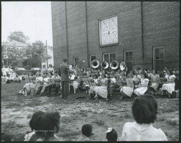 Young musicians perform behind the building. Subjects unidentified. 