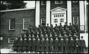 A class of graduates pose in front of the building. Subjects unidentified. 