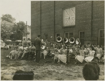 A band of young musicians plays outside Summers Memorial Building. Subjects unidentified. 