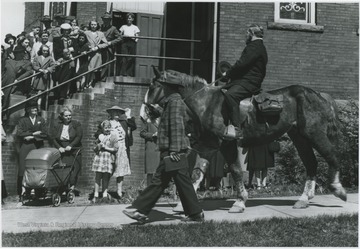 A group of spectators watch as Parker re-enacts the circuit rider next to the First Methodist Church building located on the corner of Ballengee Street and Third Avenue. 