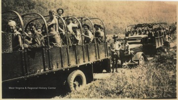 Civilian Conservation Corps members on the way to clear heavy timber for the Bluestone Dam right of way. 