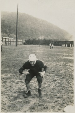 Unidentified player in tackling stance on the practice field. 
