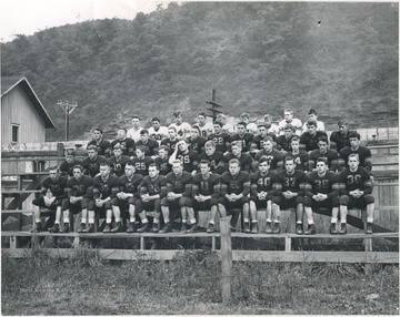 Photo caption reads, "Pat Shires led this team of Bobcats in 1946. They lost to the Eagles 19-7 but were hampered by more injuries than one shake a stick at."Front row, left to right: Charles Dobbins; Boyd Vansickle; Bobby Jack Crush; Pat Shires; Kyle Gwinn; Howard "Curly" Williams; Teddy Elmore; Virgil Moore; Jimmy Hartley; Stanley Ferguson; Kay Rogers; and Tommy Dodd.Second row, left to right: Billy Westfall; George Ames; Billy Carl Meadows; Jack Butler; W. C. Parker; Jack Yancey; Jack Johnson; Garland Tyree; Robert Morris; Bobby Hoffer; Phillip Dupreist; and Lloyd Seldomridge.Third row, left to right: Jimmy Grimmett; Marvin Steele; Jack Westfall; Ernie Moore; Richard Abbott; Bill Jenkinson; "Tootie" Wood; Benny Paul "Crow" Hellems; Dick Gunnoe; Pete Johnson; and Tommy Hellsm.Last row, left to right: Bill Apostolon, Manager; "Jake" Grimmett; Richard Neely; Benny Paul Taylor; Clifford "Bud" Ratliff; Bill "Chief' Humphreys; Tink Ritter; Charles Patrick; and Morty Meadows, Manager. 