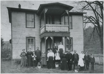 The Williams family poses in front of the house.