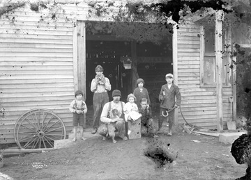 Tallest boy in back holds two new born puppies, while son on far right holds onto horseshoe and hammer.