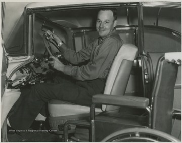 Freeland sits in the driver's seat of an automobile. 