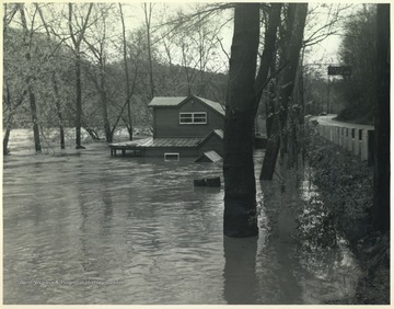 Old Kozy Cove, an establish beer joint, is pictured mostly submerged in flood waters. To the right is Route 3.