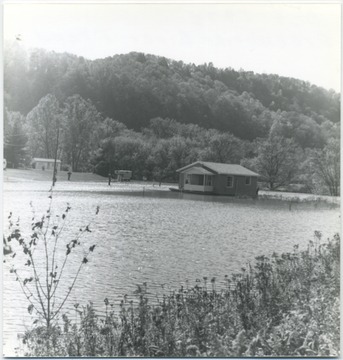 A house stands alone in the middle of the high rising waters. A person can be seen on the porch observing the situation.