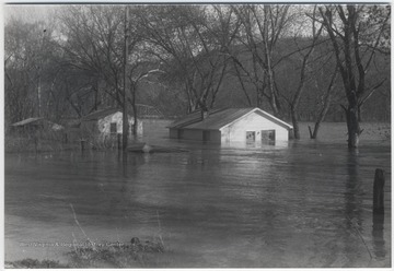 Three houses are pictured mostly under water. 