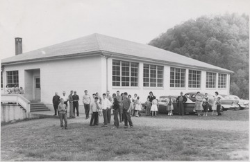 School children and parents are pictured outside the school building. Subjects unidentified.