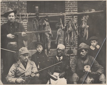 Sam Pollock, pictured on the far right with with a dog, poses with his hunting associates in front of their game. 