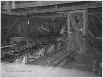Two unidentified employees pictured in the background working the sawmill.