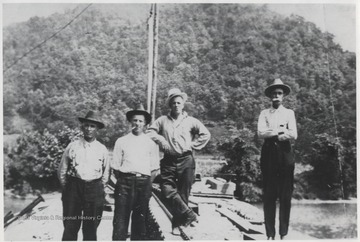 The unidentified men stand at the site located above the mouth of the Bluestone River. 