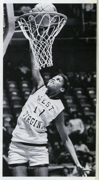 West Virginia University Women's Basketball Team member, Georgeann Wells dunks one in through the rim. In a 1984 contest against the University of Charleston, Wells was the first woman to dunk a basketball during a collegiate game. 