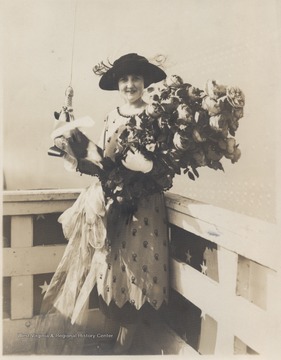 Alice Wright-Mann, of Mercer County, is pictured with a large bouquet of flowers and what appears to be a bottle of champagne.Ms. Wright-Mann sponsored the battleship which was built by the Newport News Shipbuilding and Drydock Co. of Newport News, Va. Wright-Mann was the daughter of a millionaire coalmine operator, Isaac T. Mann.