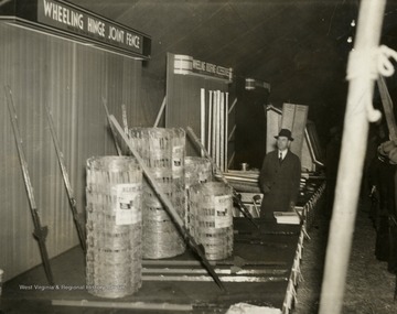Caption on back of postcard reads: "Eight large exhibits showed our products to the farmers." Wheeling Steel Corporation brought their family show on the road to the National Cornhusking Championship where performers on their radio broadcast played in front of the crowd, as well as to show off their extensive line of product offerings. This radio broadcast program began in 1936, 6 years after company executive John L. Grimes realized he could produce his own show at the same cost of advertising in a nationally known media. The broadcast was ran and operated entirely by Wheeling Steel Corporation employees and immediate family members, the first of its kind.