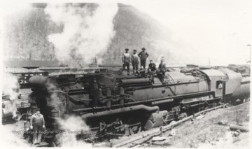Six unidentified men are pictured on top of the steaming train. 