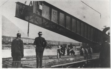 The turn table, 115 feet in length, was installed with a type twin spin-electric drive. The construction workers are unidentified. 