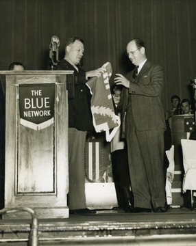 Photo taken during the Army-Navy Award presentation inside of the Capitol Theatre in Wheeling, West Virginia. The presentation was broadcast on over 127 radio stations of NBC's Blue Network, including the "It's Wheeling Steel" radio program. The "It's Wheeling Steel" radio broadcast was moved to the Capitol Theatre in Wheeling, West Virginia in 1939 as production became more polished and more and more listeners tuned in.