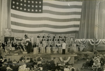 Picture taken of performance inside of WVU Field House, which was part of the "It's Wheeling Steel" radio program's "Buy a Bomber" series, where communities were challenged to buy enough Defense Bonds to purchase a bomber. The money raised in this circumstance exceeded all expectations and was the largest such fundraiser in Monongalia County, West Virginia.
