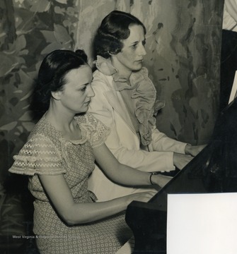 Caption on back of photograph reads: "Molly Staten and Eleanor Bowman Lynn rehearsed several weeks on their piano duet. They are stenographers from the main office of Wheeling Steel Company." Like all performers and employees on the "It's Wheeling Steel" broadcast, all were also employees or family members of the Wheeling Steel Corporation. They were radio's first all employee only broadcast.