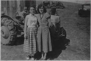 Meador, left, and Martin, right, pose together for the picture. Behind them on the tractor is a young Cletis Lyons.