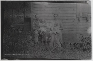 Mr. and Mrs. Hughes pictured with their two children outside their home located on the river.