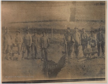 Starting on the far left is Luther Keaton, Braid Petrey, Matt Cook and Ross Farley. Pictured on the far right is L. W. "Lue" Petrey. The rest of the subjects are unidentified.The town of Narrows is named after the narrowing of New River, which runs through the town. 