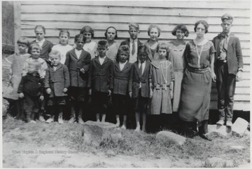 Teacher on right is Mattie Bragg who married Ivid Graham.Front row, from left to right, is unidentified, unidentified, Clytie Cox, Don Cooper, unidentified, Ernest Neely (who married Alice Hedrick), and Edna Wills (who married Joe Lemons).In the back row, the boy in the middle wearing a tie on a white shirt is Carl Meadows. The Boy to the far right, next to the teacher, is Dean Cooper.