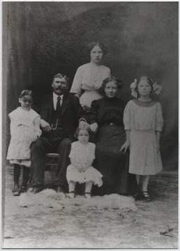 Grant Lilly and his wife pictured with their four children, three girls and one boy.