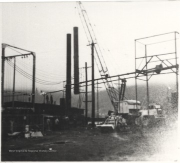 A crane lifts new smoke stacks to replace the old ones provided by Erie Iron Works in Erie, Pa. in 1924.
