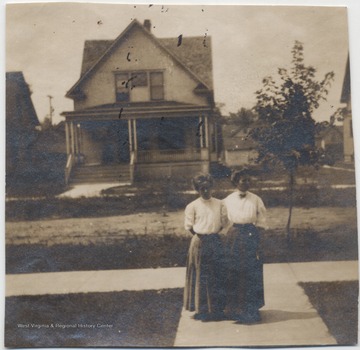 Family members of James H. Miller are pictured on the sidewalk in front of a home.
