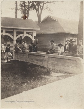 First boy pictured is Jimmy Haynes, then about age 12. Other subjects who sit along the bridge are unidentified. The spring runs directly beside the house, where Pence Spring Bottling Works collects this water for drinking.