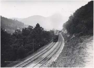 A train winds along the track placed next to New River.