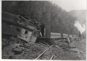 Men examine the damage along the tracks after a train derailed.