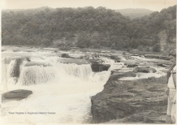 An unidentified man on the right of the photographs observes the rushing waters.