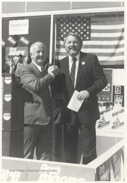 Governor Moore, left, shakes hands with an unidentified associate. Moore serves as governor from 1969-1977.