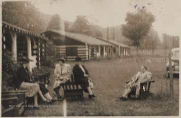 A group of women sit outside the building where the meeting is located. Subjects unidentified. 