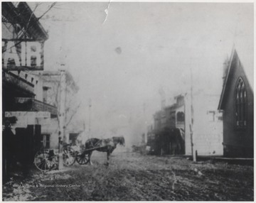 Horse connected to a carriage idles in the street. Ascension Episcopal Church pictured to the right of the photo, where Big 4 Building stands today (October 18, 1984). 